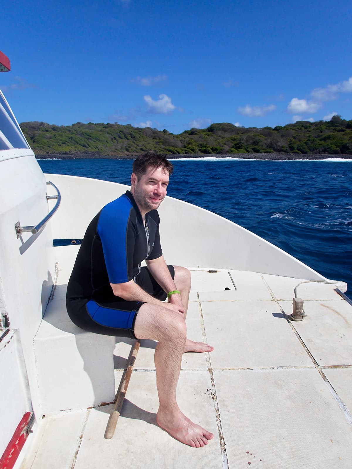 Me in a wetsuit, sitting aboard the dive boat after scuba diving for the first time